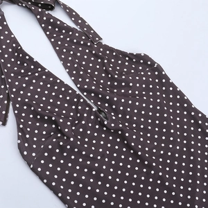Gros plan du décolleté licou et pois blancs sur robe en maille marron foncé