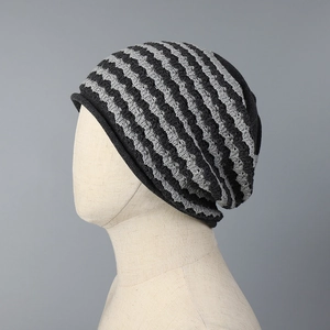 Close-up of black and grey striped knit slouchy beanie with wave pattern and rolled edge