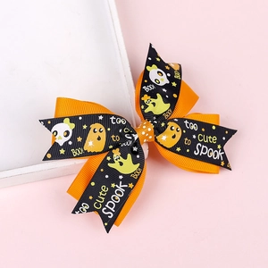 Detail of Halloween hair clips with pumpkin patterns and 'Too Cute To Spook' text