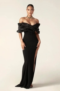 Detail of elegant black off-shoulder evening dress with pleated neckline and high slit