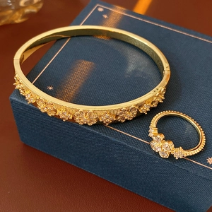 Macro detail of gold-plated clover jewelry set with sparkling zircon stones