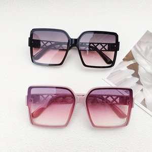 Detail shot of black and gradient pink oversized sunglasses with镂空 geometric hollow temples