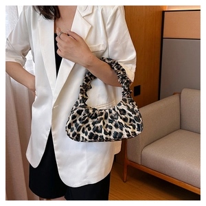 Close-up of leopard print cloud bag with ruched handle on woman in white blazer