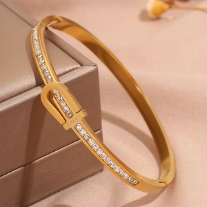 Macro detail of gold-plated stainless steel bracelet with square zircons and LOVE engraving