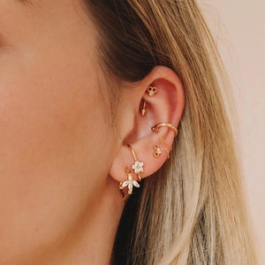 Detail view of golden S925 silver curved petal earrings with zircon stud and chain ear cuff