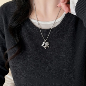 Collier cheval en argent avec pendentif gravé porté sur un pull en maille noir