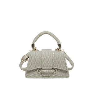 Minimalist grey woven crossbody bag with a curved top handle and golden metal buckles