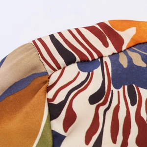 Détail d'une chemise en satin avec imprimé abstrait coloré et textures de couture