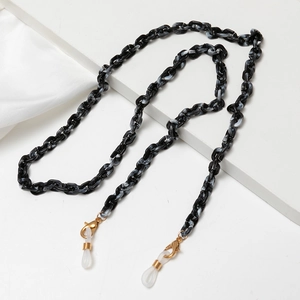 Detailed macro of marble acrylic chain link with golden lobster clasps and silicone loops