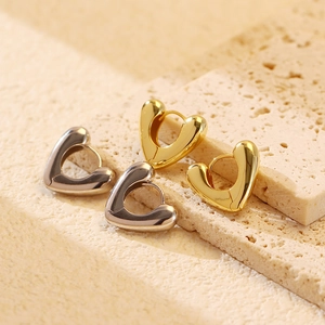 Detail of minimalist heart-shaped hoop earrings in polished gold and silver finishes