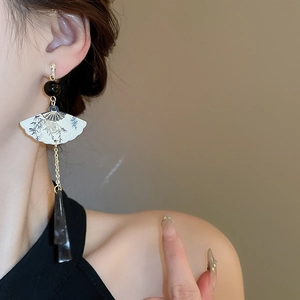 Vue détaillée d'une boucle d'oreille éventail style chinois avec motif bambou et pompon