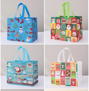 Four festive non-woven Christmas gift bags featuring colorful Santa and reindeer patterns