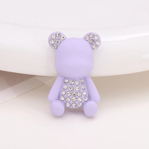 Detailed view of a purple resin bear accessory with sparkling rhinestone inlay for shoes