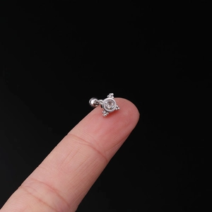 Macro shot of 20G surgical steel earring stud with zircon held on a fingertip