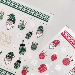 Stickers nail art de Noël avec Père Noël, flocons de neige et lettrage doré festif
