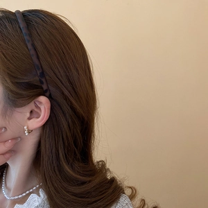 Detail of vintage gold pearl necklace and matching hoop earrings on a model