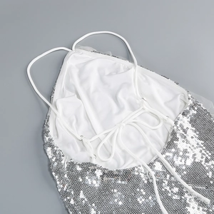 Detail of silver sequined dress featuring cross-back drawstring and backless design