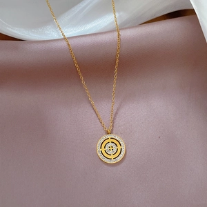 Macro detail of a gold Roman disc pendant with inlaid crystals on silk fabric