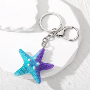 Macro shot of blue-purple gradient starfish keychain with granular texture and silver clasp