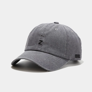 Détail du logo Z brodé et du texte 1999 sur la casquette en denim de coton gris délavé