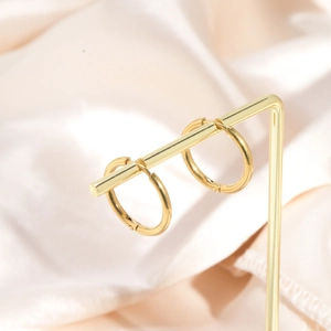 Minimalist gold hoop clip-on earrings for non-pierced ears on a T-bar display stand