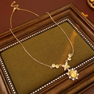 Makroaufnahme einer goldenen Vintage Sonnenblumenkette mit gelbem Zirkon im Rahmen
