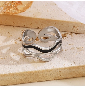 Macro view of adjustable double-layer wavy ring with black enamel on stone texture