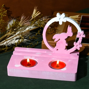 Detail of pink rabbit silhouette candle holder with rectangle marble base and red tealights