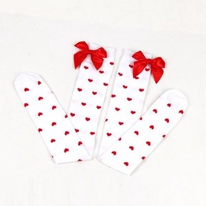 Detail showing white over-the-knee socks with red hearts and ribbon bow decoration