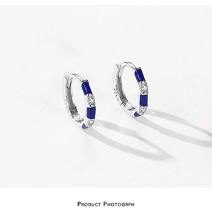 Macro shot of S925 sterling silver hoop earrings with blue enamel and zircon inlay