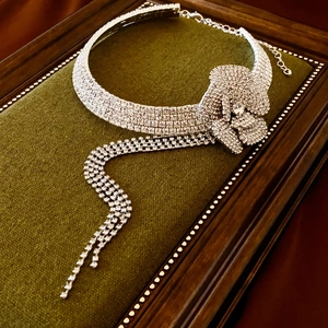 Detail of luxury silver rhinestone flower choker with elegant dangling tassels on velvet