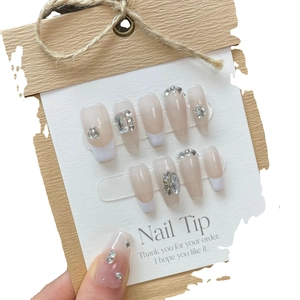 French nude press-on nails with white tips and sparkling hand-placed rhinestones