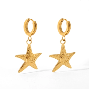 Detailed view of gold starfish drop earrings with spiral texture on white background