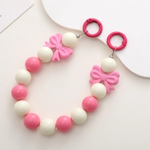 Detail of pink and cream acrylic beaded chain with two bow accents and metal rings
