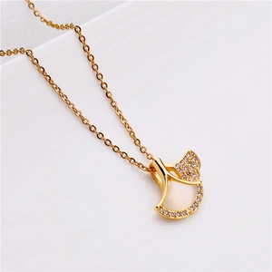 Macro shot of rose gold ginkgo leaf pendant with white shell and micro-inlaid crystals