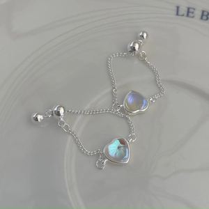 Macro view of 925 sterling silver S-chain earrings with iridescent heart pendant