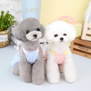 Pink and blue plaid pet dresses for small dogs shown on two toy poodles in a cozy room