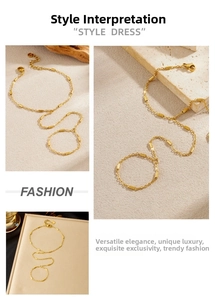 Detail of minimalist gold-plated tube chain hand chain ring showing fine linked texture