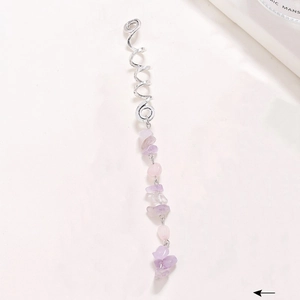 Detailed shot of silver spiral hair coil with dangling pink and purple natural stones