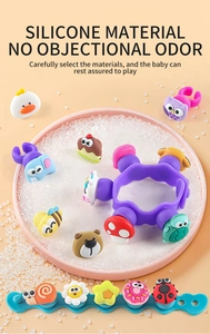 Close-up of colorful DIY silicone wristbands with cartoon charms in a pink tray