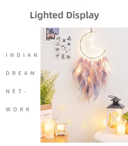 Detail of moon dreamcatcher with pink feathers and LED lights in warm room setting