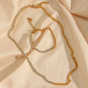 Detailed view of a gold-plated Cuban chain jewelry set with cubic zirconia on silk