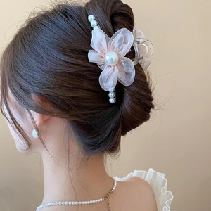 Detailed view of pink gauze flower hair claw clip with pearls and elegant petal design