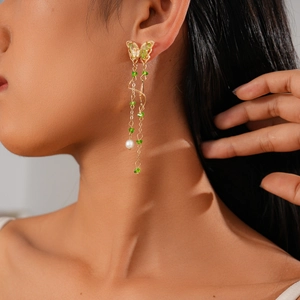Detail of green enamel butterfly earring with gold beaded tassels and white pearl