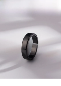 Close-up of minimalist black glossy metal ring with adjustable open band design