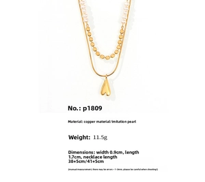 Détail d'un collier multicouche en cuivre doré avec perles d'eau douce et cœur