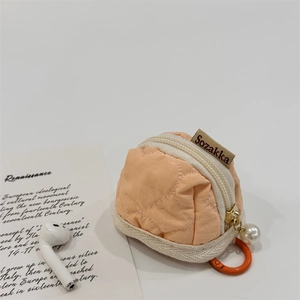 Quilted orange fabric earphone case with white pearl pendant and carabiner hook detail