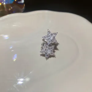 Elegant zircon double star ear cuff in silver finish displayed on a white ceramic plate