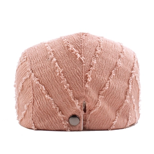Vue arrière du béret rose avec des textures effilochées et un bouton argenté au dos