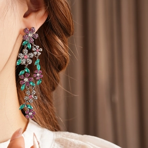 Vue détaillée des boucles d'oreilles fleurs à pompons vintage serties de strass colorés